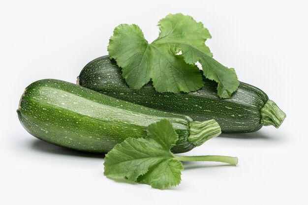 Ripe zucchini on white background with green leaf