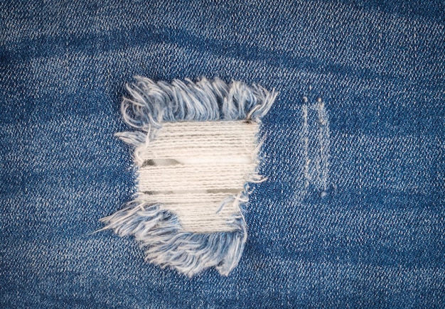 Рваные синие джинсы текстуры фона концепция моды