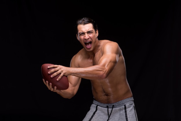 Ripped muscular man with american football