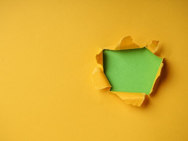 Ripped paper hole with green and yellow coloured background