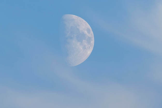 柔らかい青い空と明るい雲の上の昇る月