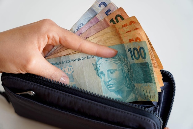 가격 상승 지갑에서 브라질 레알 지폐를 손에 넣는 손 경기 침체 금융 위기