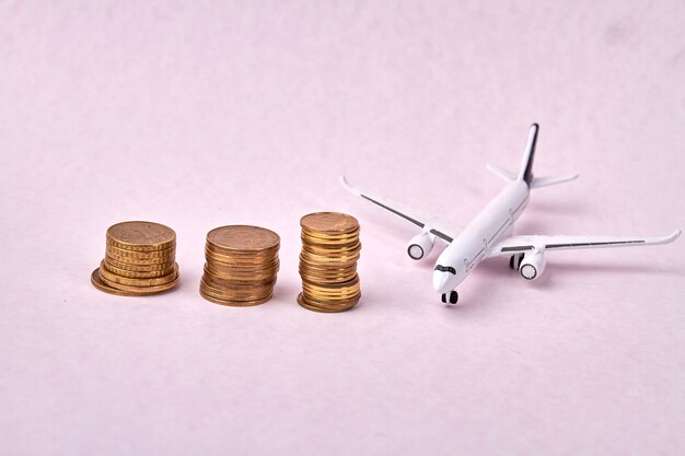 Растущая стопка монет и игрушечная модель самолета