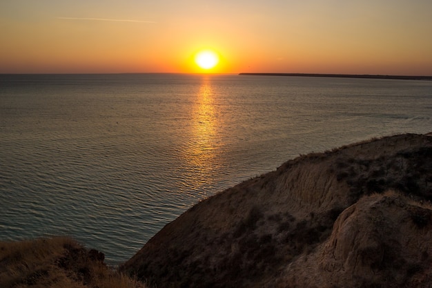 Rising sun riflettendo sull'acqua con le onde dell'oceano calmo.