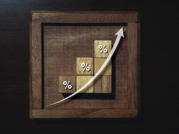 Rising up arrow on wooden blocks chart steps with percentage\
icons on wooden table, business growth process, and economic\
improvement concept.