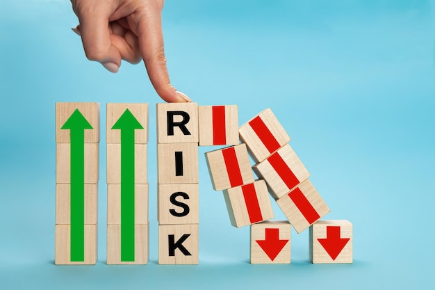 RISK cube blocks stop fall blocks protect against business crisis or risk protection concept. Hand The hand of a businesswoman who is stopping or preventing a falling block.Risk protection concept,