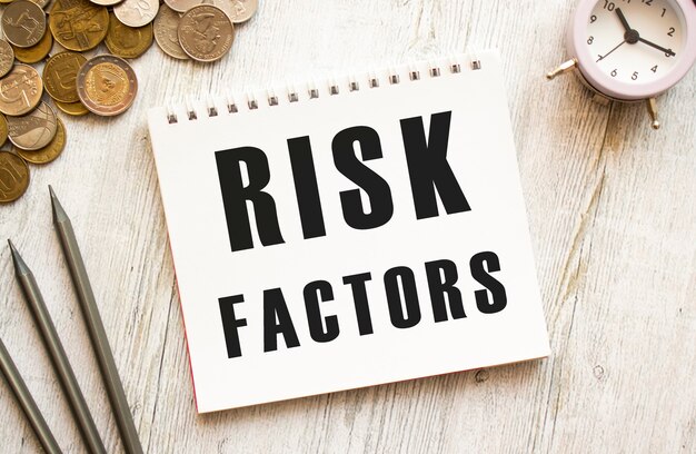 RISK FACTORS text on a sheet of notepad Coins are scattered