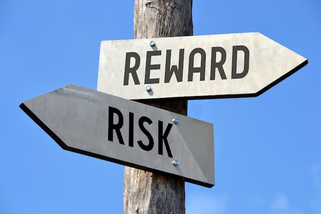 リスクと報酬の 2 つの矢印の付いた木製の道標