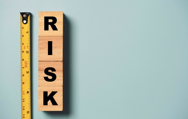 Risk wording print screen to wooden block cubes with yellow tape measurement on blue background for risk analysis assessment and management concept