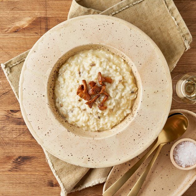 큰 접시에 살구 버섯과 리조또입니다. 전통적인 이탈리아 요리. 오래 된 나무 테이블