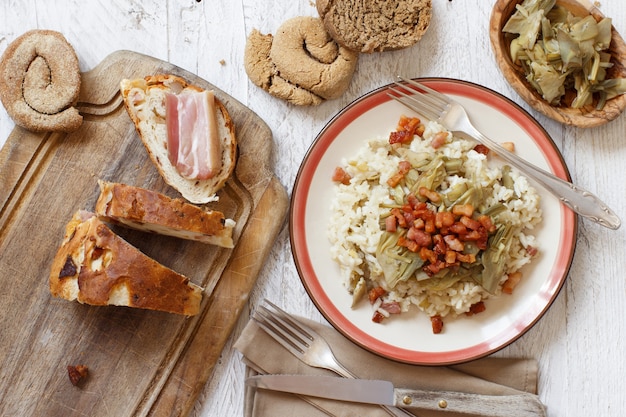 Risotto met artisjokken en spek bovenaanzicht op een houten tafelblad