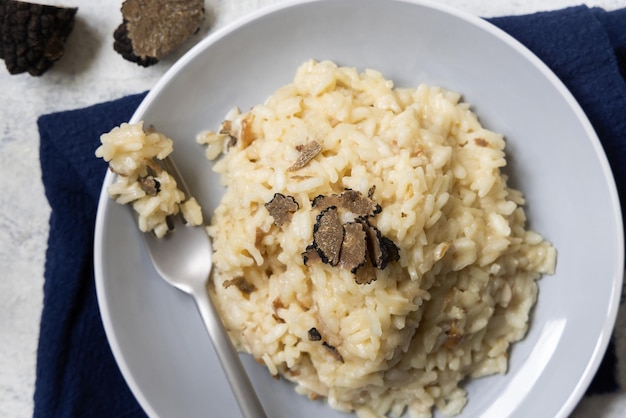 Risotto met eekhoorntjesbrood en zwarte truffels geserveerd in een gastronomische keuken van bovenaanzicht