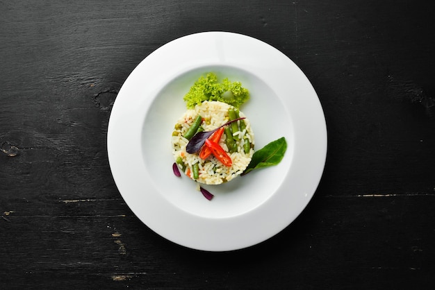 Risotto. Rice with vegetables in a plate. Top view. Free space for your text.