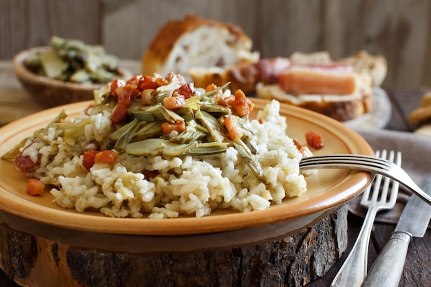 Risotto with artichokes and bacon top view on a wooden table