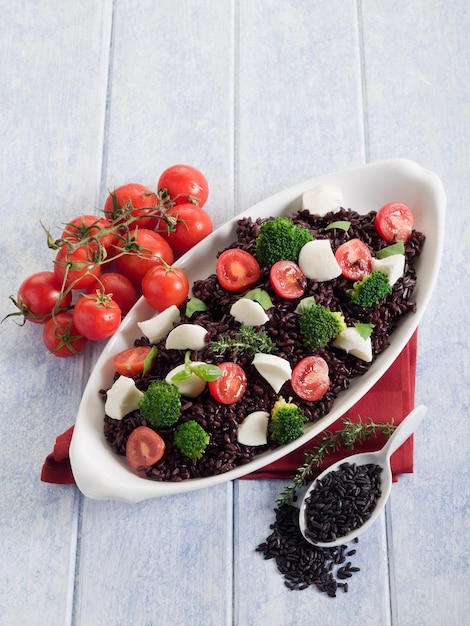 Foto risotto con riso nero broccoli pomodoro mozzarella cibo salutare