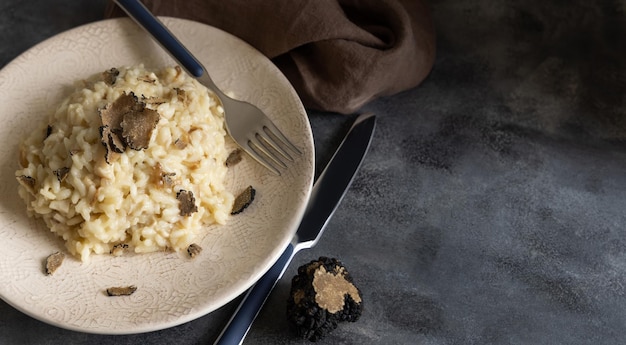 Risotto with porcini mushrooms and black truffles served in a plate top view gourmet cousine