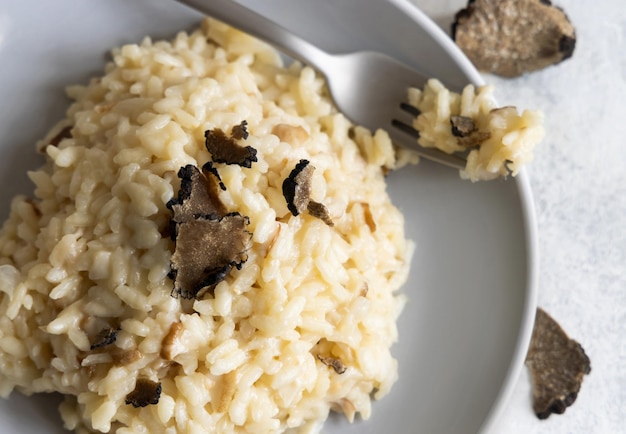 Risotto with porcini mushrooms and black truffles served in a plate top view gourmet cousine