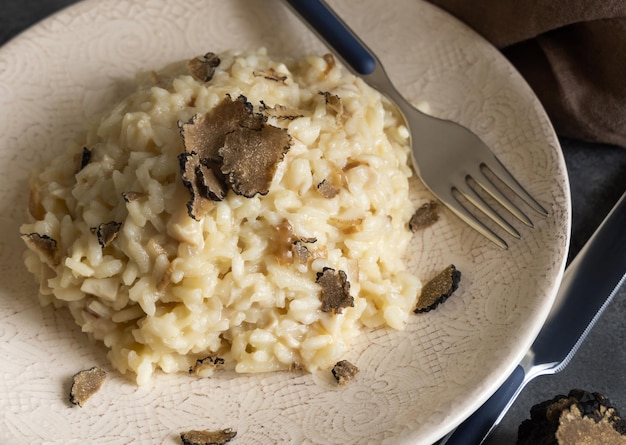 Risotto with porcini mushrooms and black truffles served in a plate top view gourmet cousine