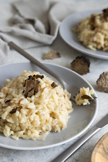 Risotto with porcini mushrooms and black truffles served in a plate top view gourmet cousine