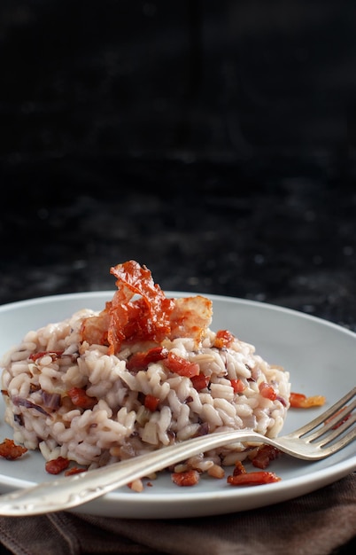 Foto risotto con radicchio rosso e speck croccante di pancetta da vicino