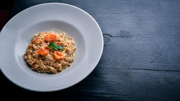 Risotto with salmon and cream sauce On a wooden background Top view Free space