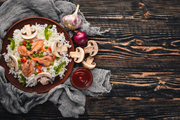 Risotto with shrimp and vegetables Seafood Asian cuisine On a wooden texture background Top view Free space