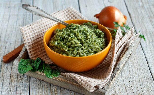 Risotto with spinach cream in a bowl close up