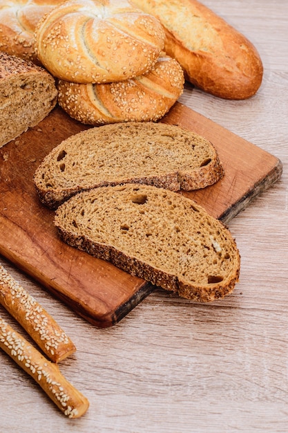 Ð¡risp bread with buns. French baguettes. Fresh crispbread. Bread background. Different breed  on wooden background.