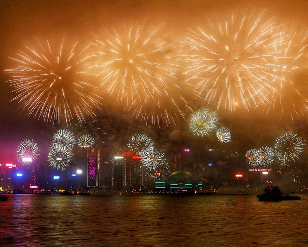 River against firework display in city at night