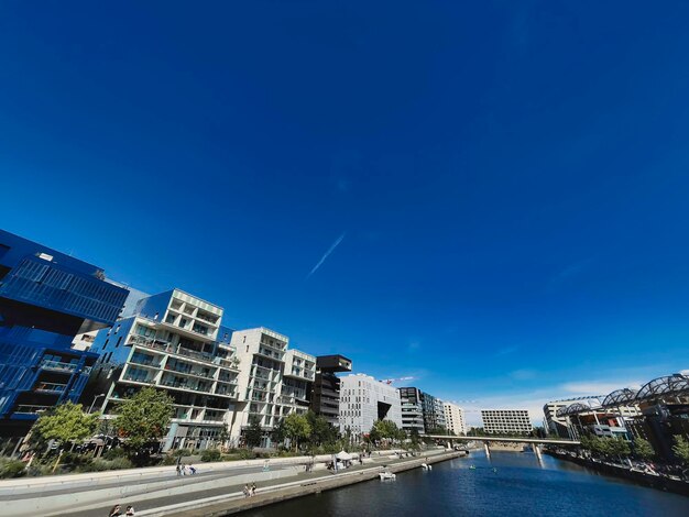 River amidst buildings against blue sky