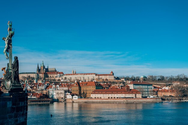 River amidst buildings in city against blue sky