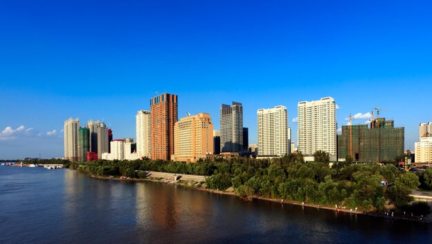 River amidst buildings in city against clear blue sky