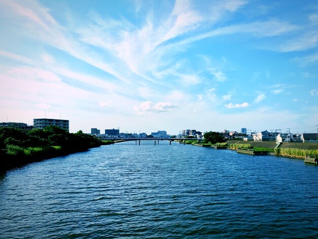 Photo river amidst buildings in city against sky