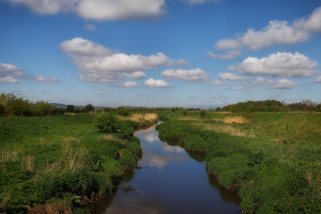 River and blue sky with clouds.