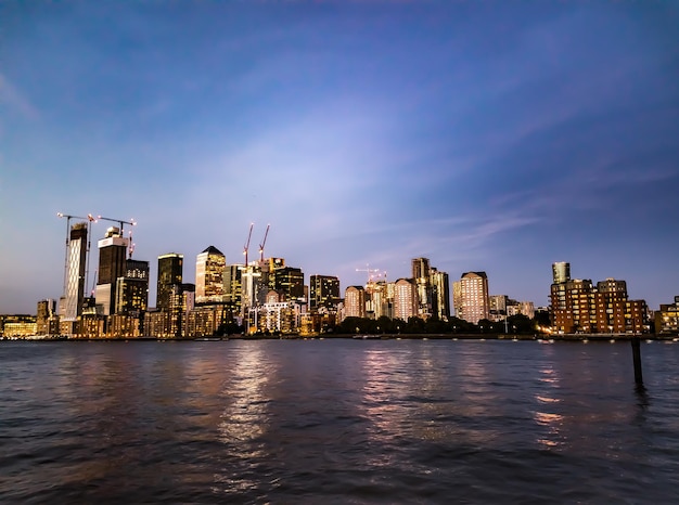 Photo river by buildings against sky in city