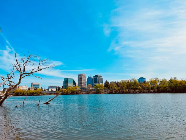 River by buildings against sky