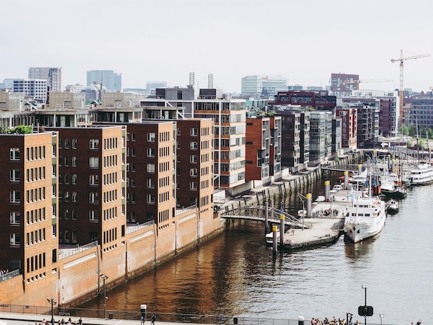 River by buildings in city against clear sky