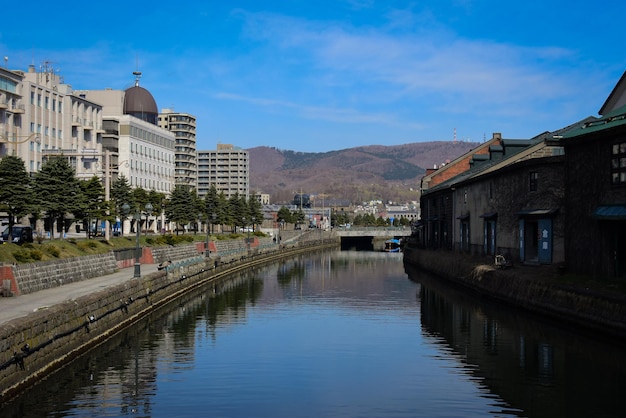 River by buildings in city against sky