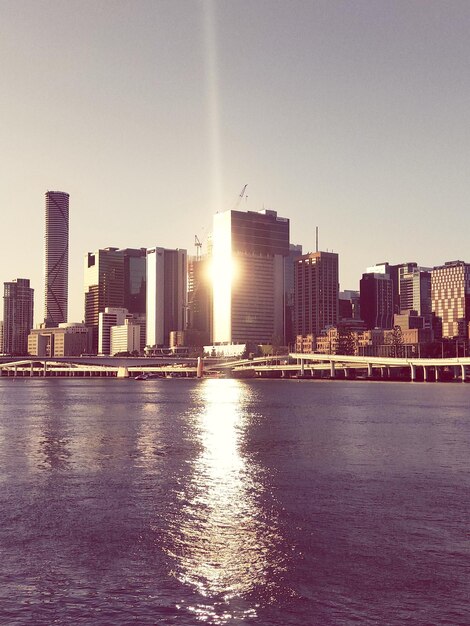 Photo river by city buildings against clear sky