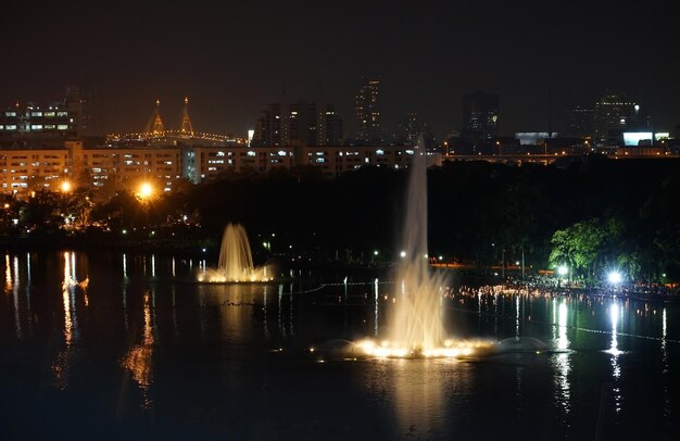 River by illuminated city against sky at night