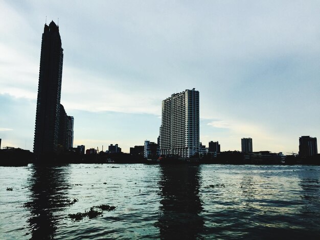 Photo river by modern buildings against sky in city