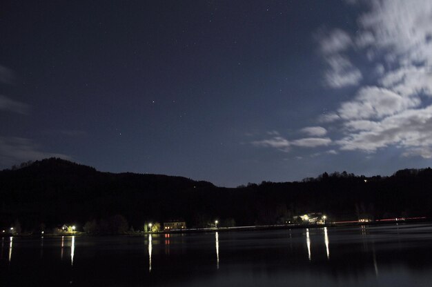 写真 夜の空を背景にした山のシルエットによる川