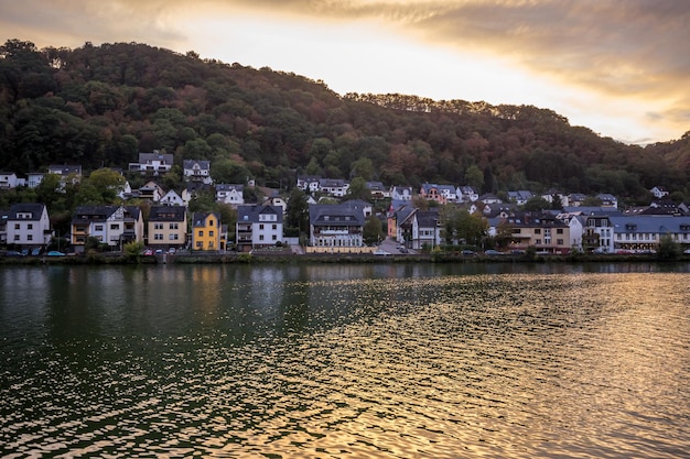 River by townscape against sky at sunset