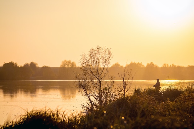 River and fisherman on the shore during the sunset_