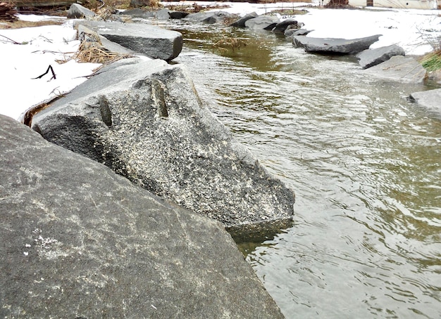 The river flows through the stones in spring