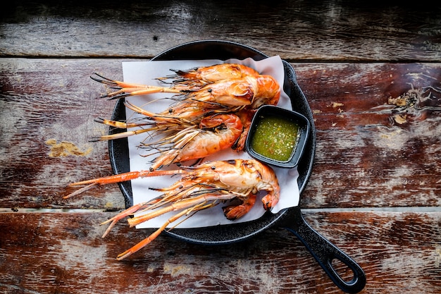 River prawns burned in a hot pan used as plate.