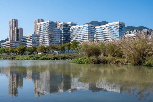 Photo the river reflects the modern city buildings under the blue sky