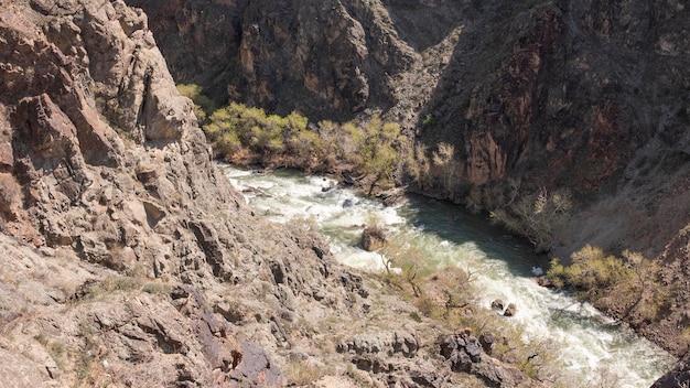 A river runs through a canyon with a boat in the foreground.