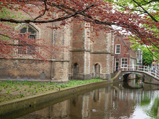 Photo a river runs through a city with a bridge and a building with a bridge in the background