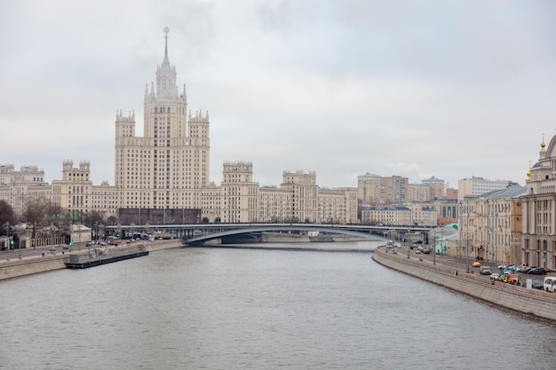 A river runs through a city with a large building on the left side.